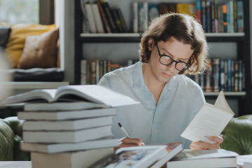 Person reading pile of books